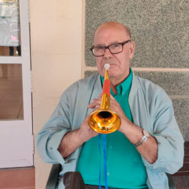 Usuario de la Residencia Escoriza, perteneciente a Grupo Aconser, con una trompeta por las actividades realizadas con motivo de la Semana Santa