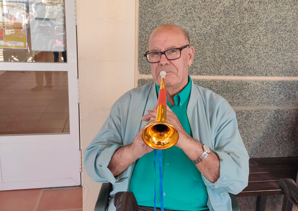 Usuario de la Residencia Escoriza, perteneciente a Grupo Aconser, con una trompeta por las actividades realizadas con motivo de la Semana Santa